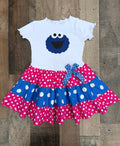 Children's dress with Cookie Monster design on a wooden background
