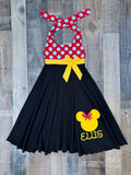 A custom Minnie Mouse-inspired costume dress for kids, featuring a red and white polka-dot halter top, a yellow waist bow, and a black pleated skirt with a yellow Mickey Mouse head graphic and the name 'ELIS' in script.